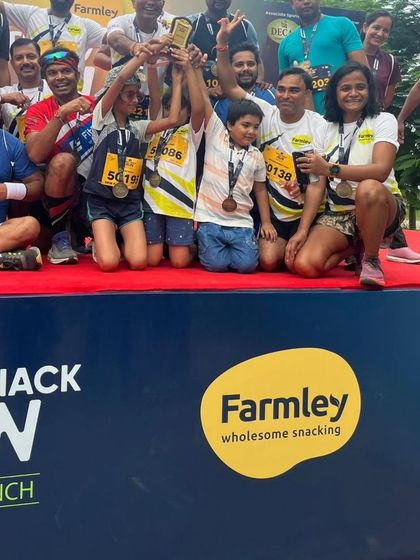A team celebrating their win on the podium at the Farmley Snack Run. We encourage healthy competition and celebrate every victory, big or small.