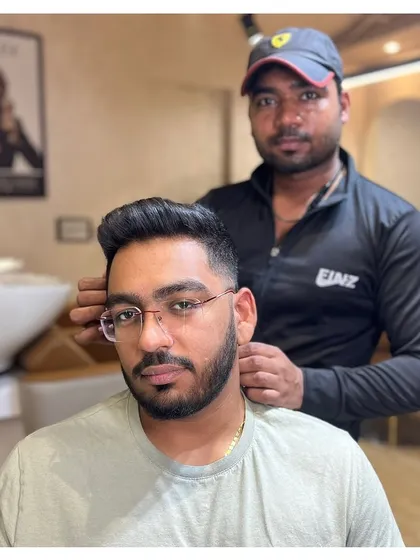 Our stylist putting the finishing touches on a client's haircut and beard. We ensure every detail is perfect before you leave the chair.