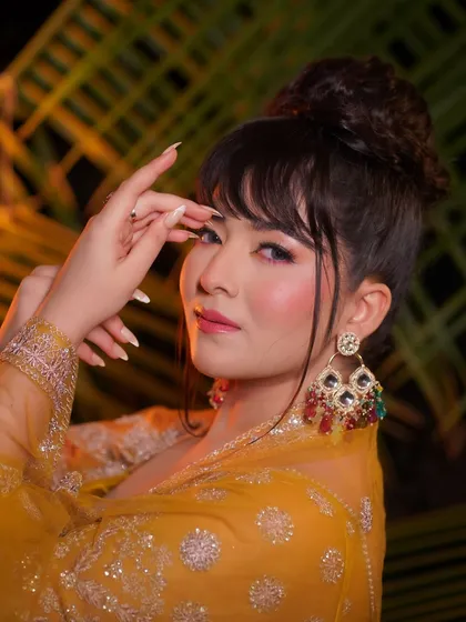 Another angle of the Haldi glam, showing how the makeup looks from the side. The large, colorful earrings complete the festive vibe.