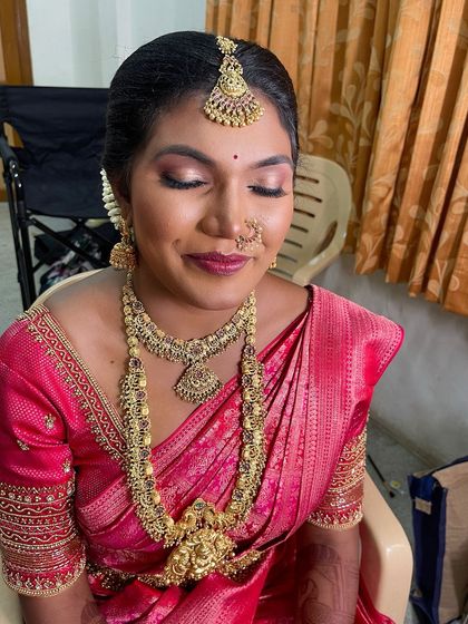 A close-up of my bride Karthiga's Muhurtham makeup. The look features a bold, warm-toned eyeshadow and a deep red lip that beautifully complements her dusky complexion and pink saree.