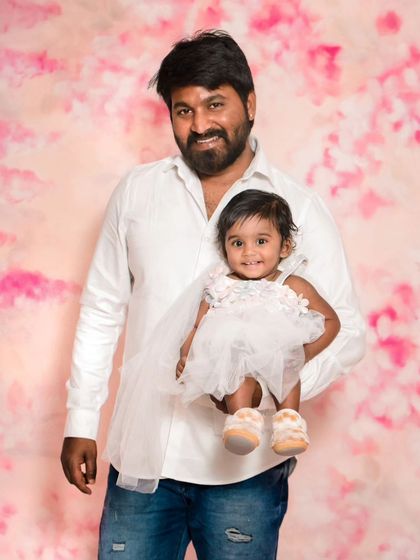 A classic father-daughter portrait from the studio session. The simple background allows all the focus to be on their happy faces and connection.