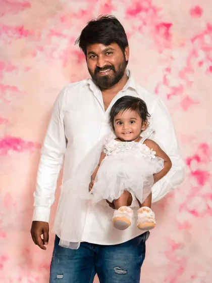 A father holds his little girl in a classic portrait pose. This simple and sweet shot is a wonderful way to document your child's milestones.