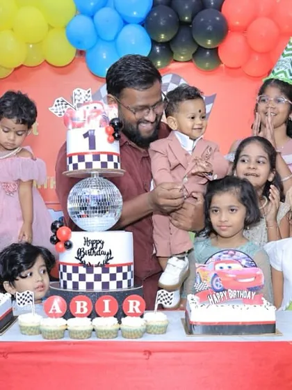 A happy family photo capturing the joy of a first birthday celebration.