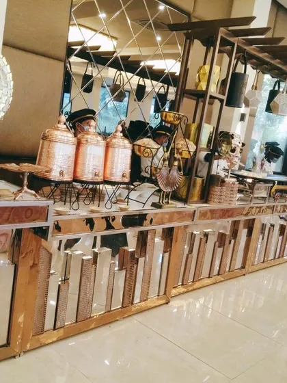 A modern buffet counter with a mirrored, cityscape-style base and copper-toned accents. This setup is perfect for corporate events or contemporary weddings, blending style with function.