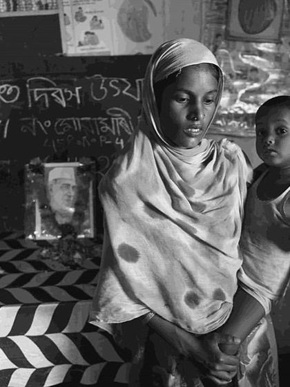 A woman and child stand before a chalkboard in a community centre. The image provides a glimpse into the local settings where health and nutrition initiatives take place.