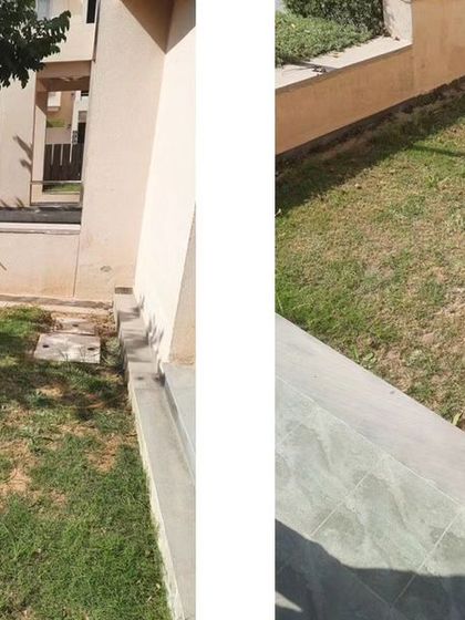 The existing front lawn of a duplex villa, a simple and undeveloped patch of grass.