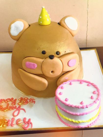 Another view of the giant teddy bear cake, highlighting its cute expression and the mini cake alongside it. We love bringing our clients' creative ideas to life.