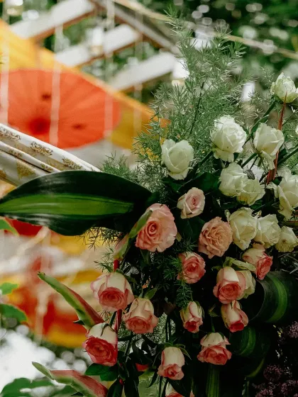 A detailed shot of the lush floral arrangements, combining white and pink roses with fresh greenery for an elegant touch.