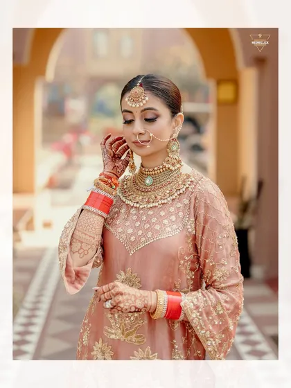 A close-up portrait of the bride, highlighting the intricate details of her makeup, jewelry, and the beautiful embroidery on her outfit.