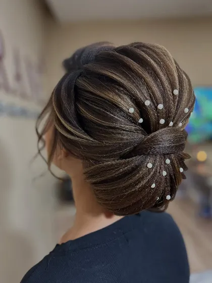 Another angle of the pearl-adorned updo, showcasing the clean, professional finish.