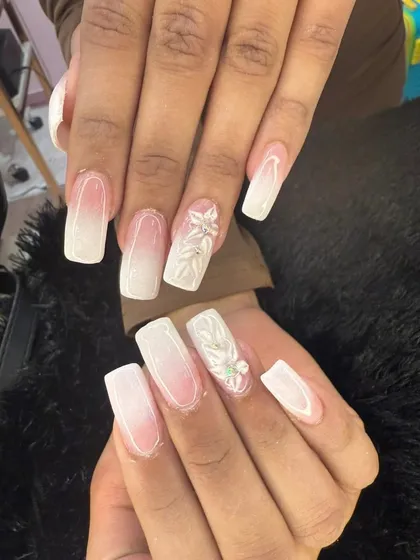 A beautiful example of modern bridal nails. This set features a soft white ombre on a squared nail shape, with intricate 3D floral accents on a few nails for a touch of texture and romance.