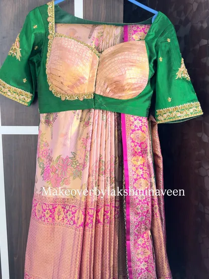A pre-draped half-saree ready for a client, showing the perfect pleats and combination of a floral saree with a green blouse.