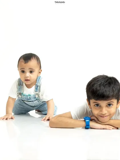 A sweet portrait of two brothers in our studio. The older brother protectively rests his arm on his baby brother, showcasing the special bond between siblings.
