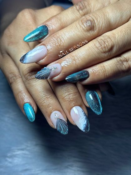 Moody mermaid nails with a mix of teal cat eye, black, and white marble, and 3D shell accents.
