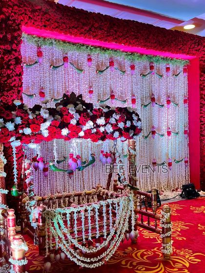 A full view of the cradle ceremony setup. The cradle is the centerpiece, surrounded by a stunning backdrop of fresh flowers and traditional elements, creating a perfect setting for the ceremony.