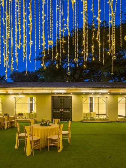 A night view of the Gallops lawn, where the fairy lights create a canopy of light against the twilight sky. This setup is perfect for outdoor receptions and dinners, offering a truly enchanting experience.
