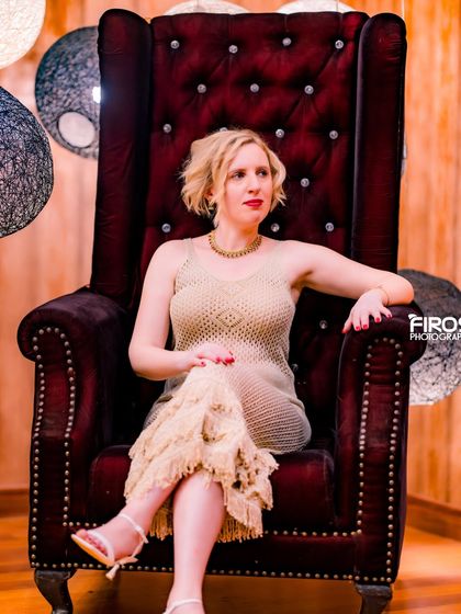 A regal portrait of a model sitting on a throne-like chair in our royal room.