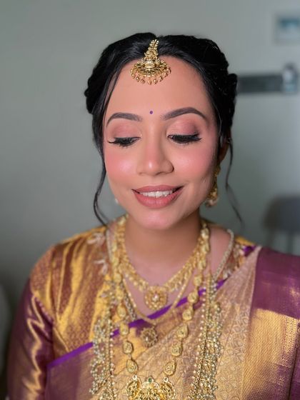 Soft-focus skin and a muted mauve lip for Archana's modern yet rooted South Indian bridal glam.