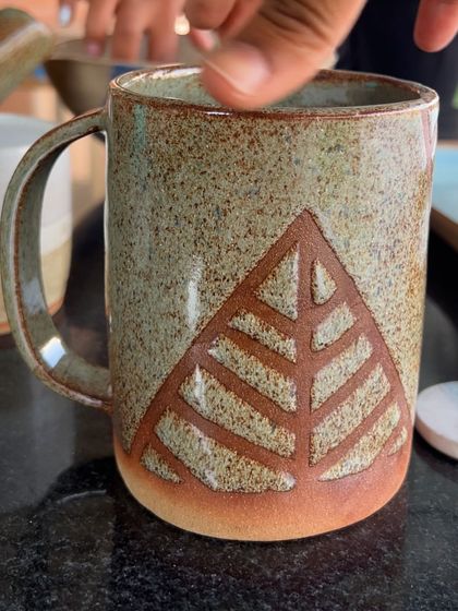 A rustic, carved mug made by Poonam. The geometric leaf design is simple yet very effective.