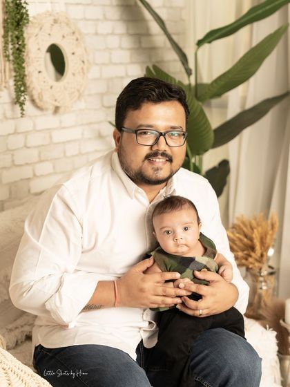 A father and his baby boy share a quiet moment. This portrait captures the gentle bond between them in a modern, relaxed studio setting.