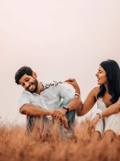A playful moment captured in a field at dusk, showing the fun and lighthearted side of the couple's relationship.