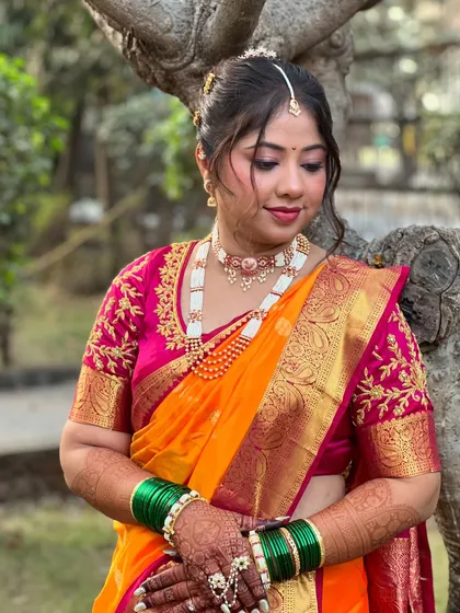 An elegant nauvari saree look for my bride Darshana, featuring a beautiful orange and pink silk saree and traditional pearl jewellery.