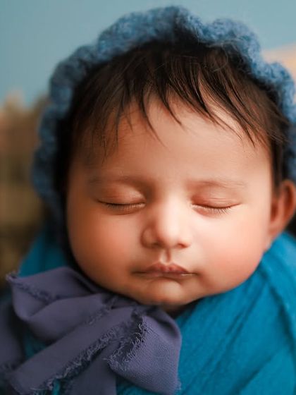 The richness of this deep blue wrap and bonnet makes this baby's peaceful features stand out so beautifully. It's a wonderful color choice for a baby boy's first portrait session.