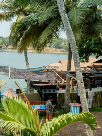 A view of the Mehendi festival setup by the lake in Kerala. The decor is a mix of natural elements, like palm trees, and quirky, colorful art installations, creating a breezy and relaxed escape.