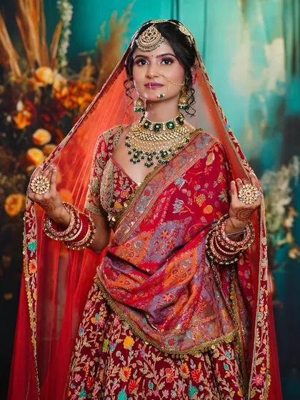 The bride holds her dupatta, a classic pose that our students learn to capture. The makeup remains flawless and is the centerpiece of the look.