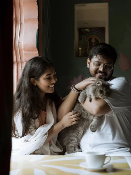 A heartwarming and authentic moment as the couple shares a laugh while cuddling their beloved cat. Including pets makes a pre-wedding shoot truly personal.