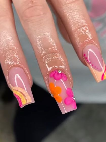A close-up of the intricate, multi-colored floral and rainbow nail art, showing the detailed layering and 3D elements.