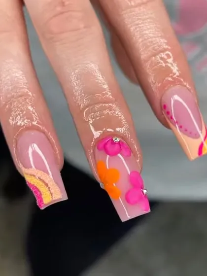 A detailed shot of the vibrant 70s-inspired floral and rainbow nail art.