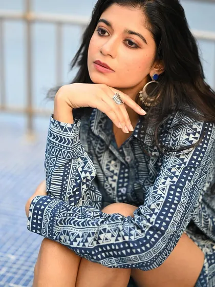 A pensive portrait of the model in the blue dress. The composition is simple and clean, focusing on her mood and the details of the print.