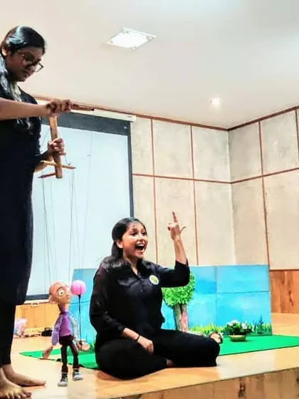 A dynamic shot of our team performing on stage, combining puppetry with live narration.