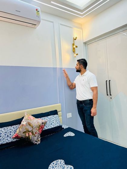 A simple yet stylish bedroom with a two-tone blue and white painted wall and elegant wall sconces.