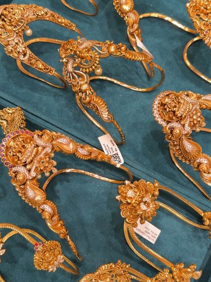 Here you can see a variety of my bajuband designs laid out. Each piece has unique detailing, from peacock motifs to floral patterns, all with an antique gold look.