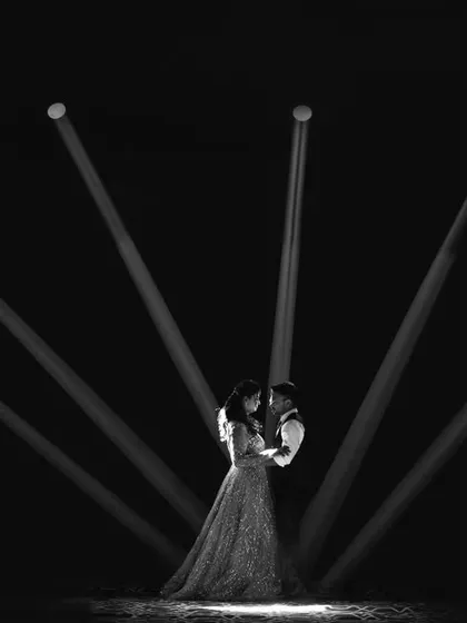 A dramatic black and white portrait. We used spotlights to create a theatrical and artistic image of the couple in a romantic embrace.