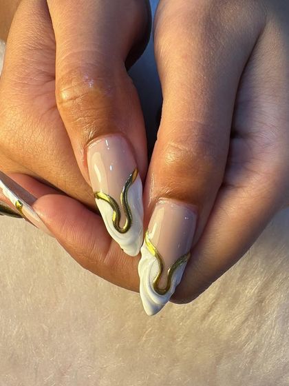 A closer look at our sculpted gold and white nail art. You can see the precision in the raised white texture and the smooth, liquid-like application of the gold chrome accent.