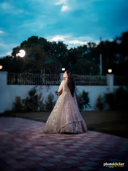 A stunning solo portrait of the bride-to-be at her engagement, using the dramatic evening sky as a backdrop to create a powerful image.
