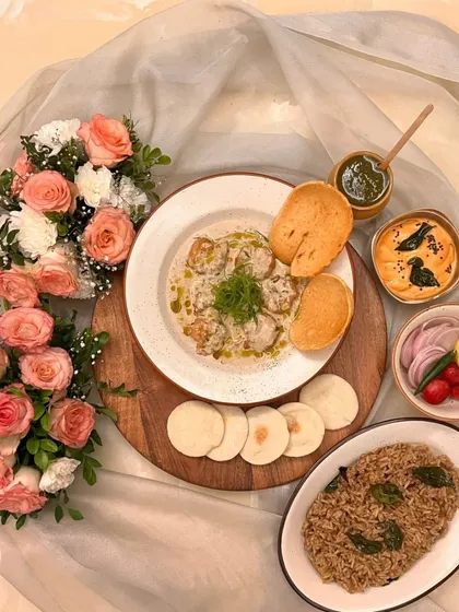 This is my modern take on a seafood classic, the Green Chili Malai Prawns platter. It features succulent Andaman prawns in a creamy butter sauce, served as a complete meal with pulao, chutneys, and dips for a full dining experience.