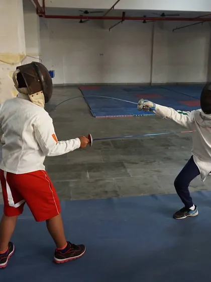 Two young fencers engage in a practice bout. This is where technique meets tactics, as students learn to read their opponent and apply the skills learned in drills.