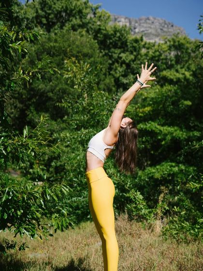 Practicing Tadasana (Mountain Pose) outdoors, as shown here, can enhance the experience. This foundational pose improves circulation and focus by encouraging mindful alignment.