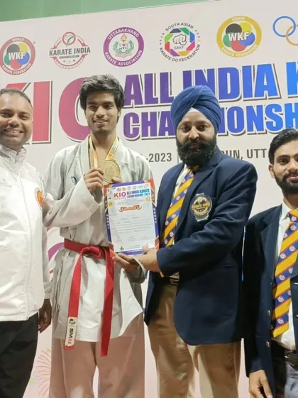 Receiving congratulations and the gold medal from officials at the KIO All India Karate Championship.
