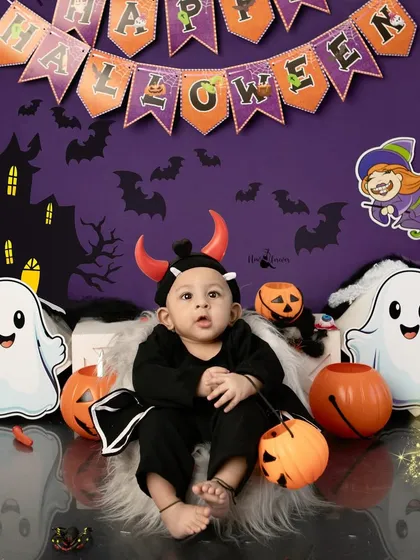 A little devil with horns sits among the spooky decorations. Our Halloween set is designed to be fun and engaging for kids.