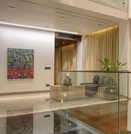 A view from the glass bridge, looking down into one of the living areas. The design emphasizes transparency and a multi-level living experience.