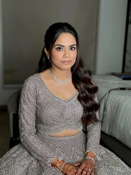 Looking straight at the camera, her confidence shines. The dewy glam is perfect for a Sangeet night, designed to catch the light as she moves.