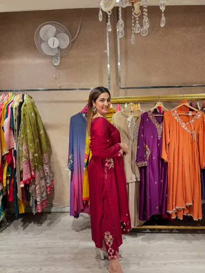 A side profile of the wine-colored suit, highlighting the delicate embroidery on the sleeves and pants. These small details are what make an outfit truly special and luxurious.