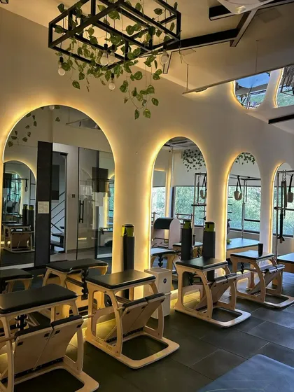 The Pilates chairs and arched mirrors create a unique workout environment. This setup is perfect for targeting specific muscle groups with precision.