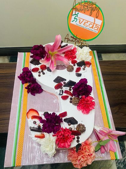 A close-up of our number '9' anniversary cake, beautifully decorated with flowers and treats for the special occasion.