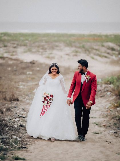 A full-length walking shot of the couple on the beach. This captures the movement and romance of a destination wedding photoshoot.
